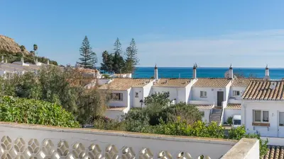 a row of white houses with the ocean in the background at Casa da Areia, Three Bedroom Villa by the Beach in Luz