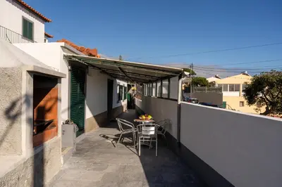 a couch with a yellow pillow and a coffee table at Casa da Avo Belinha in Funchal