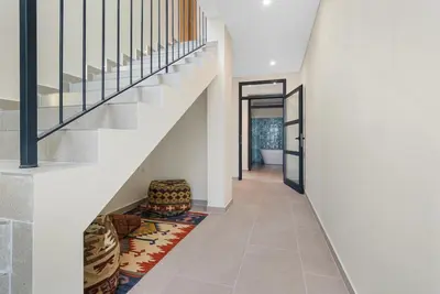 a hallway with a staircase with a chair and a rug at Casa da boa vista in Canhas