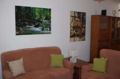 a living room with a couch and two paintings on the wall at !Your Home In Madeira in Funchal