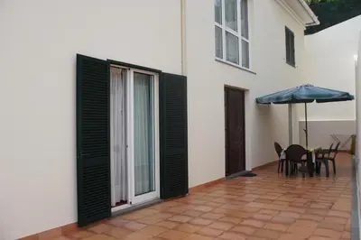 a patio with black shutters on a white building at !Your Home In Madeira in Funchal
