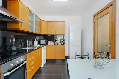 a kitchen with a washing machine and a table at Agostinho Apartment Santa Cruz in Santa Cruz