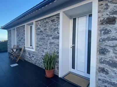 a balcony of a house with a door and a plant at My little home cottage in Porto Moniz