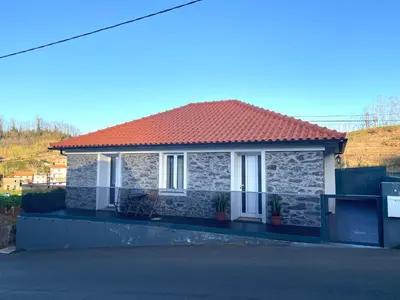 a small house with a red roof on a street at My little home cottage in Porto Moniz