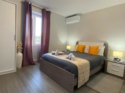 a bedroom with a bed with orange pillows and a window at My little home cottage in Porto Moniz