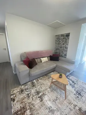 a living room with a couch and a table at My little home cottage in Porto Moniz