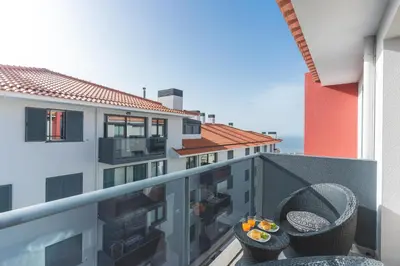 a balcony of a building with two chairs on it at Garajau Comfort Stay by Atlantic Holiday in Caniço