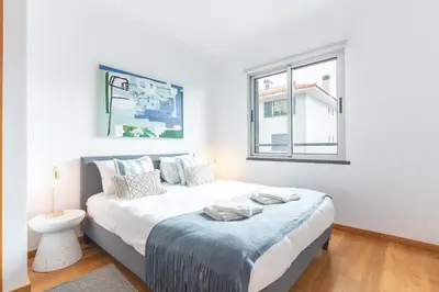 a bedroom with a large bed with a window at Garajau Comfort Stay by Atlantic Holiday in Caniço