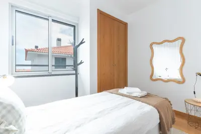 a white bedroom with a bed and a window at Garajau Comfort Stay by Atlantic Holiday in Caniço