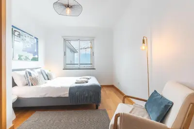 a bedroom with a bed and a couch and a window at Garajau Comfort Stay by Atlantic Holiday in Caniço