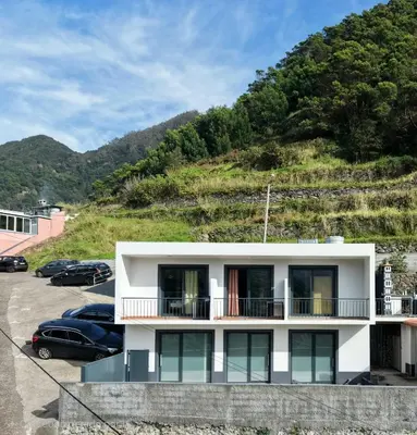 a bedroom with a large sliding glass door with a table at Seaside & Levada Escape in Machico