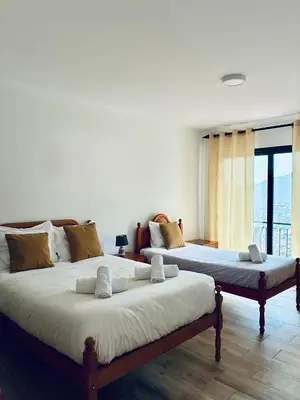 a bedroom with a bed and a dresser and a mirror at Seaside & Levada Escape in Machico