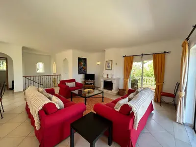 a living room with red couches and a fireplace at Luxury 4 Bedroom Algarve Villa with Private Pool in Budens