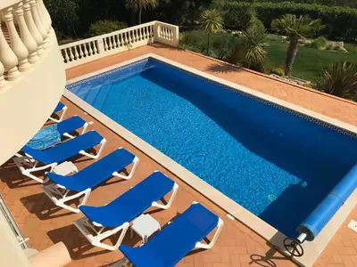 a pool with lounge chairs and a swimming pool at Luxury 4 Bedroom Algarve Villa with Private Pool in Budens