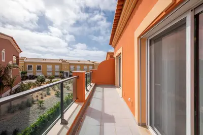 a kitchen with white cabinets and a table and chairs at Boavista Golf & Spa - Villa Paul at Bayview Village in Lagos