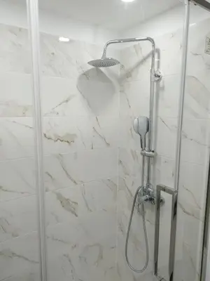a shower in a bathroom with white marble at charnecas house in Gaula