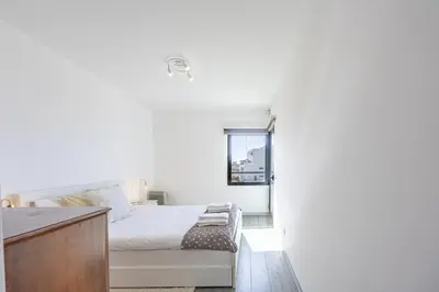 a white bedroom with a bed and a window at Lux Mare Funchal by YOUR KEY MADEIRA in Funchal