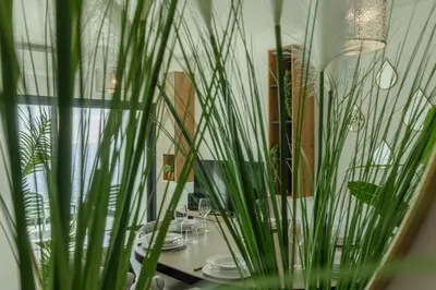 a table with plates and plants in a vase at Alma do mar luxury - Ocean front in Gaula
