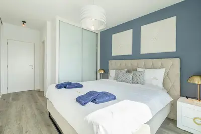 a bedroom with a large white bed with blue walls at Alma do mar luxury - Ocean front in Gaula