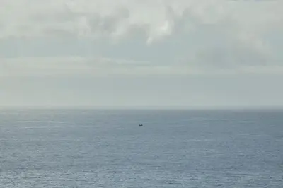 a view of the ocean with a boat in the water at Alma do mar luxury - Ocean front in Gaula