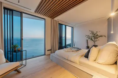 a bedroom with a large bed with a large window at Aurora Residence - Ultra Luxury Ocean Cliff Edge Retreat in Arco da Calheta
