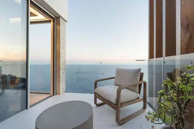 a chair in a room with a view of the ocean at Aurora Residence - Ultra Luxury Ocean Cliff Edge Retreat in Arco da Calheta