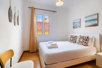a bedroom with a white bed and a window at GuestReady - Casa Martins in Machico