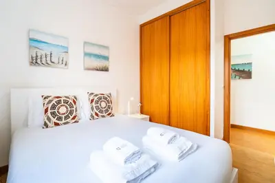 a bedroom with a white bed with towels on it at GuestReady - Casa Martins in Machico