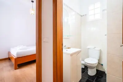 a bathroom with a toilet and a sink and a shower at GuestReady - Casa Martins in Machico