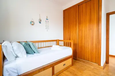 a bedroom with a bed with a wooden cabinet at GuestReady - Casa Martins in Machico