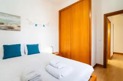 a bedroom with a white bed with blue pillows at GuestReady - Casa Martins in Machico