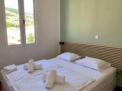 a small bedroom with a bed and a mirror at Residencial do Vale in Funchal