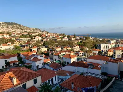 a view of a city at sunset from a balcony at Residencial do Vale in Funchal