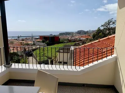 an aerial view of a city with houses and the ocean at Residencial do Vale in Funchal