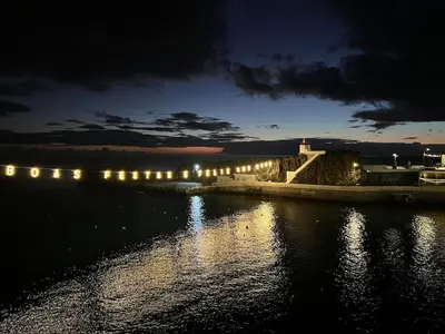 a row of lights on the water at night at Atlantic Residence Pool & Ocean View in Câmara de Lobos