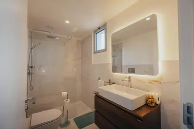 a bathroom with a sink and a shower and a mirror at Atlantic Residence Pool & Ocean View in Câmara de Lobos
