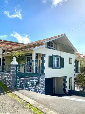a white and black house with a balcony at 