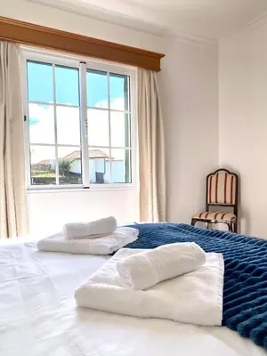 a bedroom with two pillows on a bed with a window at 