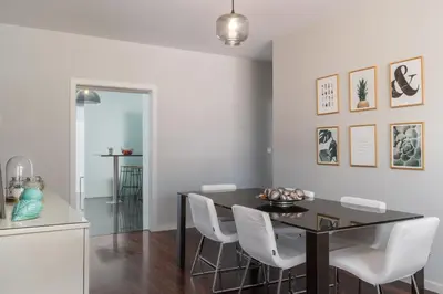 a dining room with a black table and white chairs at Stay Orange Modern Apartment in Funchal in Funchal