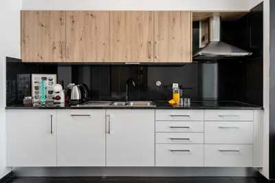 a kitchen with white cabinets and a sink at Stay Orange Modern Apartment in Funchal in Funchal