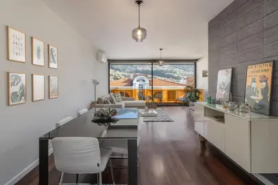 a living room with a table and chairs and a house at Stay Orange Modern Apartment in Funchal in Funchal