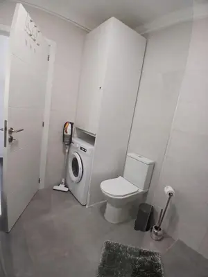 a bathroom with a toilet and a washing machine at RJ Summer in Sagres