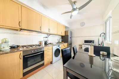 a kitchen with a table and chairs and a stove at Ocean Gardens Apartment by Mth in Caniço