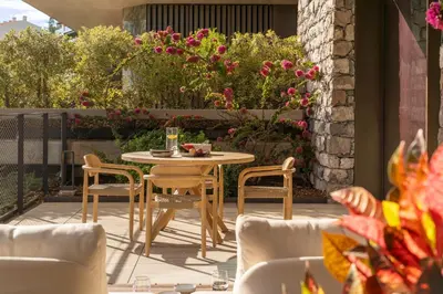 a table and chairs on a patio with flowers at Savoy Monumentalis XI Luxury with sea view in Funchal