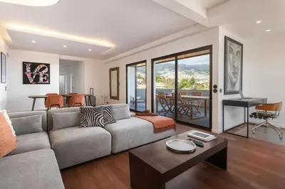 a living room with a couch and a table at Monumental Alta Vista Panoramic View Balcony in Funchal
