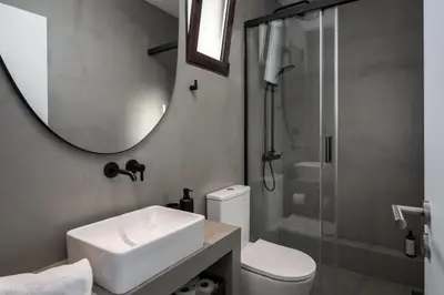 a bathroom with a sink and a mirror and a toilet at Monumental Alta Vista Panoramic View Balcony in Funchal