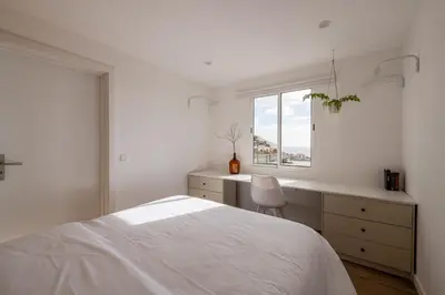 a white bedroom with a bed and a desk and a window at Horizon Madeira View in Funchal