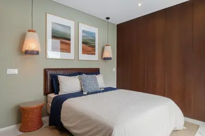 a bedroom with a bed and two pictures on the wall at Arbor Villa: Nature Retreat in Campanário