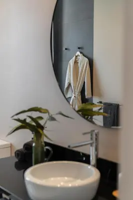 a bathroom with a sink and a mirror at Arbor Villa: Nature Retreat in Campanário