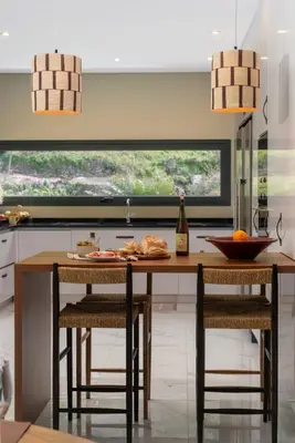 a kitchen with a table with chairs and a window at Arbor Villa: Nature Retreat in Campanário